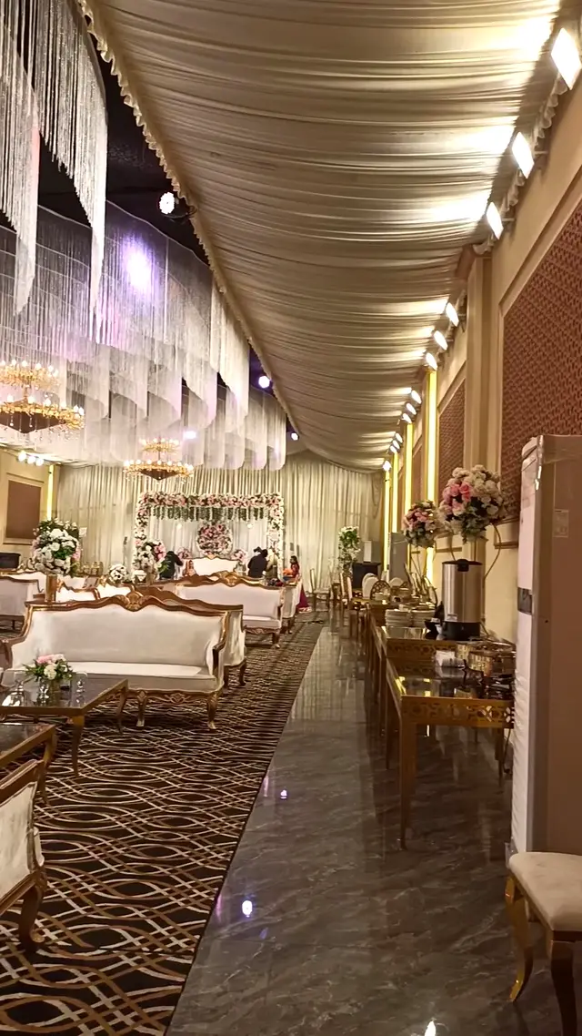 Chandeliers down the aisle between lounge sofas