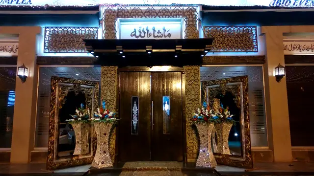Gold carved main entrance with flower stands