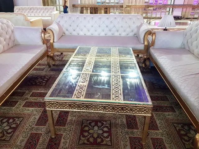 Carved glass coffee table between ivory sofas
