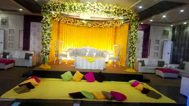 Yellow mehndi stage with floor cushions