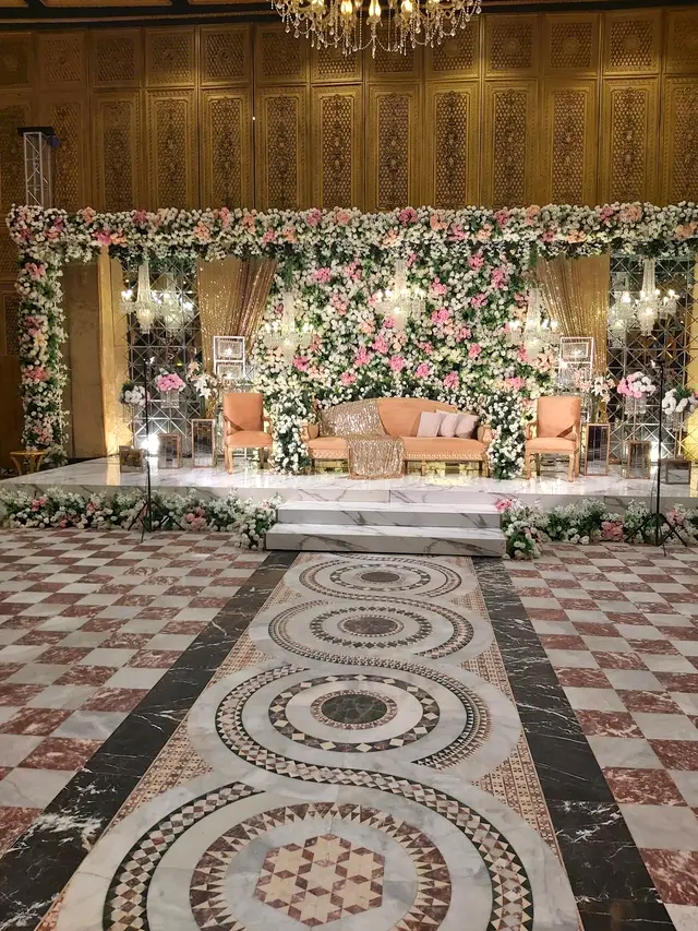 Pink and white flower wall stage with a mosaic aisle