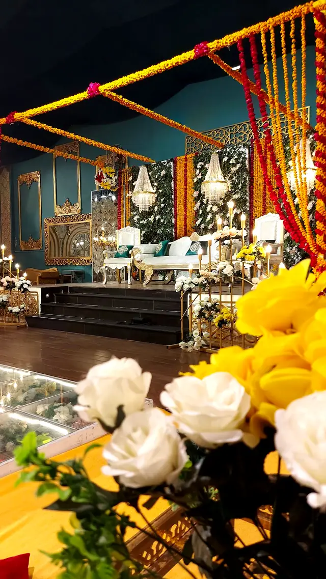 Mehndi stage with yellow flowers in the teal hall