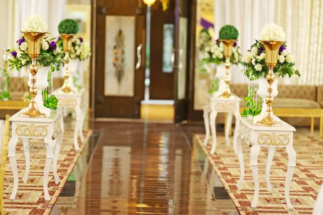 White pedestal vases lining a polished aisle